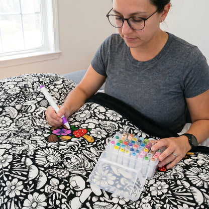 Family enjoying screen-free time coloring a blanket together