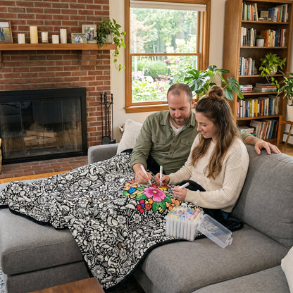 Couple coloring a blanket together on the sofa